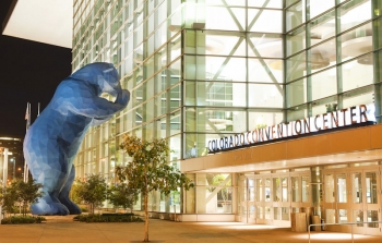 Denver Convention Center's large blue bear looking in through the window.