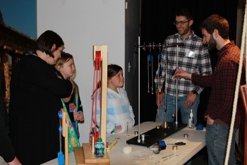 Fluor Idaho mechanical engineers Chris Graham and Derek Allen demonstrate how pulleys can provide a mechanical advantage to lifting heavy weights to, from left, Jennifer Redman and her daughters Emma and Abby.
