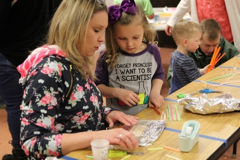 Lea Squires and her daughter Rylea fashion a container used to test Archimedes theory of water displacement.