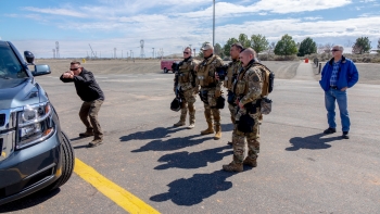 During the NNSA active shooter training exercise at the Hanford Site, an expert demonstrates using a patrol vehicleâs engine block as effective cover.