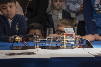 Children watch as a fuel cell turns hydrogen into energy.