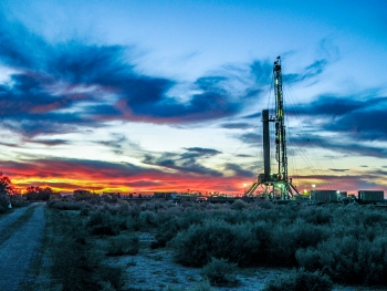 Image of a sunset behind a geothermal hole drilling.