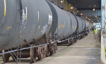 A deactivation worker inspects railcars containing insulating oil from the Paducah Siteâs C-533 Switchyard as they are prepared to be shipped to a buyer for the Paducah Area Community Reuse Organization.