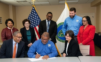 S. Richard Hagins, CEO of US&S, a small business subcontractor at the Savannah River Site, signs a mentor-protégé agreement during a Savannah River Nuclear Solutions (SRNS) Mentor-Protégé Center of Excellence team meeting.