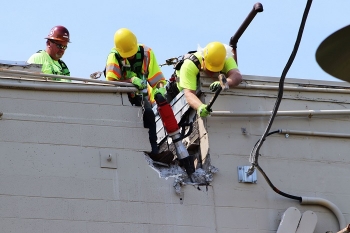 Workers carefully divide the east and west portions of Building 3017 before major demolition begins.