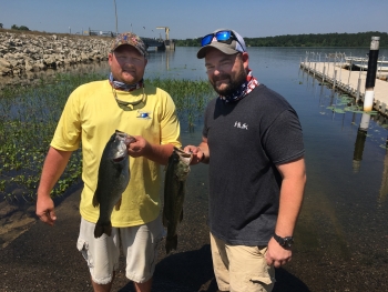 Savannah River Nuclear Solutions employee and veteran Jeffrey Lanier (right), a former Apache Helicopter Crew Chief in Afghanistan, and his brother Ronald, each hold a large bass caught during the Ultimate Fishing Challenge, recently held at SRS to honor