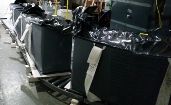 Three 900-pound lift bags filled with asbestos material sit on a conveyor system designed by workers at EMâs West Valley Demonstration Project.