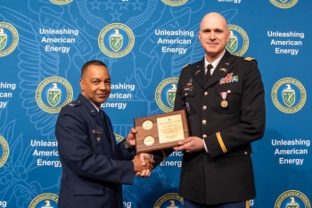 Col Michael Clancy, former Executive Director of Major Modernization Programs, present Lt. Col. Greg Schwarz with a plaque in recognition of his 23 years of exception service in the U.S. Army.