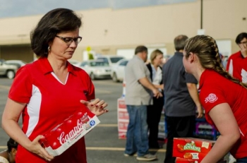 FRNP Deputy Program Manager and Chief Operating Officer Myrna Redfield helps interns load canned food and supplies onto trucks going to local nonprofit kitchens and pantries.