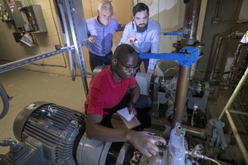 Joseph Tuozzolo (left) and J.T. Benante (right), provide guidance to intern Steven Snell, who is checking the status of a pump that is part of the cooling system at the AGS. Joseph Tuozzolo (left) and J.T. Benante (right), provide guidance to intern Steven Snell, who is checking the status of a pump that is part of the cooling system at the AGS.
