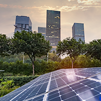 Solar panels in the foreground with a city skyline in the background on a partially cloudy day.