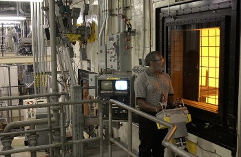 An operator at the Defense Waste Processing Facility maneuvers a canister inside the DWPF canyon via remote controls. All radioactive operations inside DWPF are conducted remotely.
