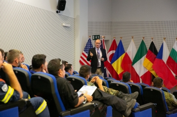 Andrae Brooks explaining NNSAâs role in supporting NATO with emergency preparedness and response training.