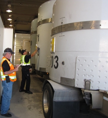 Fluor Idaho Transportation Certification Official Shawn Strozzi, left, double-checks the 500th shipment's manifest as Idaho State Trooper Peter Sibus conducts an inspection of the shipment.
