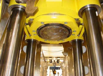The supercompactor, above, and its hydraulic ram, at left, apply more than 4 million pounds of pressure to 55-gallon waste drums to create five-inch-thick âpucksâ that are loaded into overpack drums in preparation for off-site disposal.