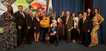 Event participants pose smiling in front of the stage