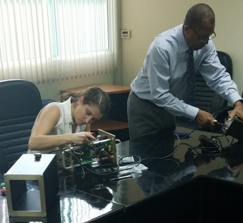 Emily Jackson and James Butler from NNSAâs Remote Sensing Laboratory adjust SPARCS equipment in Thailand.