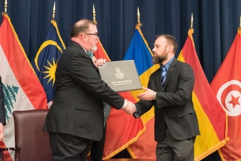 OST Federal Agent Chris Sterie receives a diploma from Dr. Charles B. Cushman, Chancellor, College of International Security Affairs.
