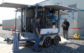 Mission Support Alliance substation electrician Matthew Starkey, left, and environmental compliance officer Mike Demiter perform oil reconditioning on a transformer in the 200 West Area.