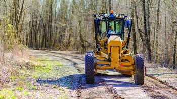 Heavy Equipment Operator Jeff Walls grades one of the 32 miles of roads maintained by Swift & Staley Inc. at the Paducah Site.