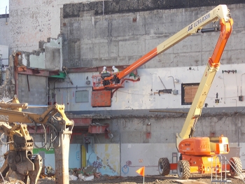 Radiation technicians from area small business InTomes survey of the exposed exterior wall of the Main Plant Process Building at EMâs West Valley Demonstration Project Site after the demolition of the Main Plant Office Building.