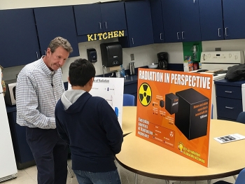 Joe Biggerstaff, a radiological protection integration and technical manager with UCOR, provides information about the sources of radiation to an attendee at the STEM event.