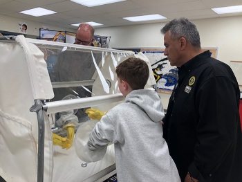 James Nunz, project management branch chief for Oak Ridgeâs EM program, teaches students how to use a glovebox during a demonstration at the STEM event.