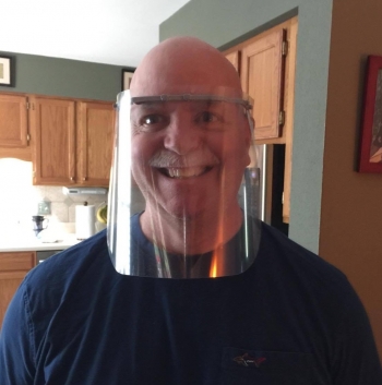 A recipient of the personal protective equipment models one of Scott Hawks' creations. Hawks prints the frame to hold the plastic shield.