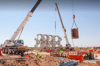 A bucket of excavated dirt is lifted out of the utility shaft at the Waste Isolation Pilot Plant site.