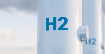 Tall white hydrogen tanks with H2 painted in blue on the front.