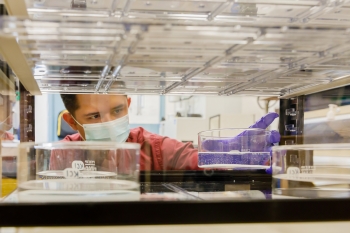 Sandia National Laboratories principal investigator Michael Omana inserts a solution into a small chamber used to increase humidity on material samples.