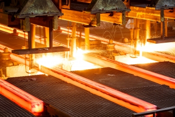 Hot steel going through conveyor belt at a steel manufacturing plant Hot steel going through conveyor belt at a steel manufacturing plant