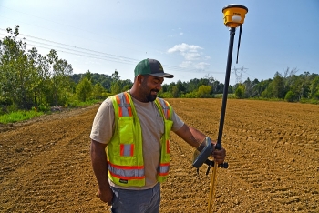 An EM worker relies on a handheld device with GPS technology to ensure precise soil coverage over the various contours of a former oil tank farm site at Oak Ridge.