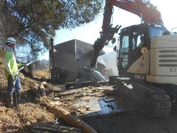 Jayme Gillen, an employee with North Wind Portage, EM's cleanup contractor at the former Energy Technology Engineering Center site, sprays water to mitigate dust while crews demolish one of eight DOE-owned buildings remaining at the site.