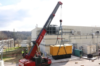 Workers install a backup diesel generator at Building 2026. If there is a loss of power, it can produce enough power to maintain operation of equipment necessary to process uranium-233 at Oak Ridge.