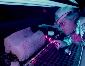A scientist uses ultra-violet light to study how fluids move through rock