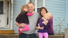 Photo of a family standing in front of a house.
