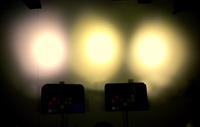 Photo of a dark wall with three LED lights shining on it.