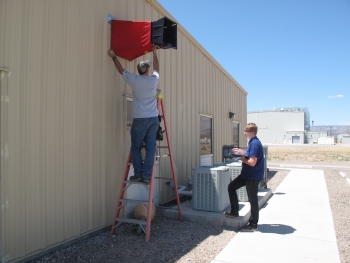Two men take air-flow measurements at the Field Engineering Building