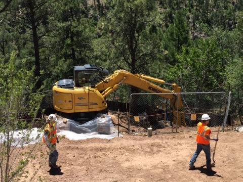 Workers stage equipment prior to removing contaminated soil.