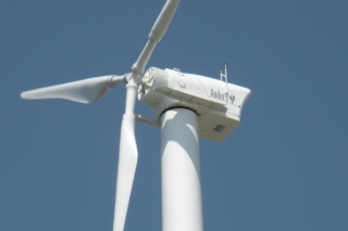 Northern Power Systems 100-kilowatt wind turbine. <em>Photo courtesy Northern Power Systems</em> A photo of a wind turbine from the point of view of looking upward at the blades and nacelle.