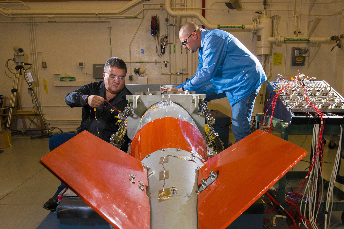 Two technicians working on the B61 in the vibration shock lab